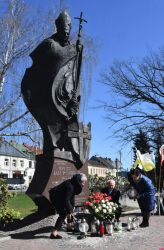 władze miasta składają wiązankę z biało-czerwonych kwiatów pod pomnikiem Jana Pawła II
