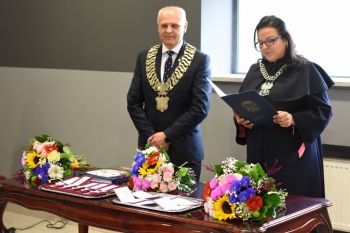 burmistrz miasta i kierownik USC, na stole leżą kwiaty, medale i legitymacje