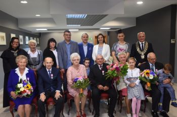 trzy pary jubilatów z kwiatami i medalami, burmistrz miasta i kierownik USC oraz goście