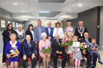 trzy pary jubilatów z kwiatami i medalami, burmistrz miasta i kierownik USC oraz goście
