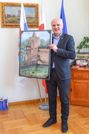 burmistrz Rawy Mazowieckiej Piotr Irla trzyma obraz Zamku Książąt Mazowieckich