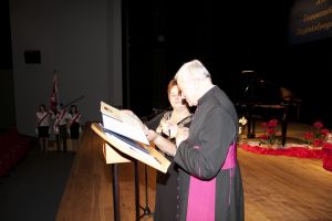 prałat Iwanicki ;podpisuje dyplom honorowego obywatela, na scenie MDK