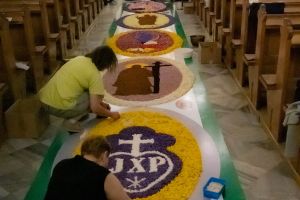 kościół oo. Pasjonistów, kilka kobiet układa dywan z płatków kwiatowych