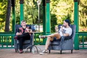 Jakub Żulczyk i dyrektor MBP siedzą na fotelach w altanie parkowej