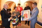 burmistrz i przewodnicząca przekazują prezenty marszałkowi