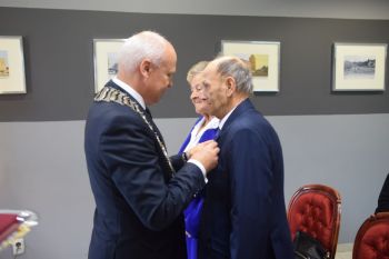 burmistrz przypina medal jubilatowi