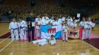 grupa rawskich karateków z trenerem z flagami klubu i miasta
