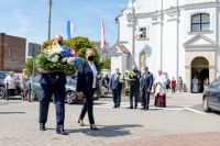 przedstawiciele gminy niosą wieniec pod pomnik św. Jana Pawła II