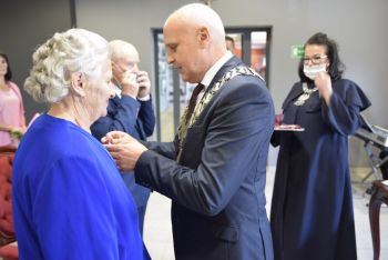 burmistrz dekoruje jubilatkę medalem za długoletnie pożycie