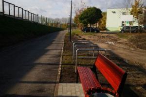 ławka z koszem na śmieci, stojaki na rowery, widok na wiadukt obwodnicy