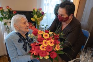 Przewodnicząca Rady Miasta Grażyna Dębska wręcza bukiet kolorowych kwiatów jubilatce