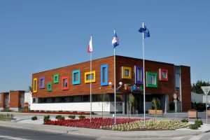 Elewacja frontowa żłobka, flagi na masztach przed budynkiem