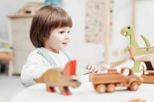 dziecko bawi sie drewnianymi zabawkami