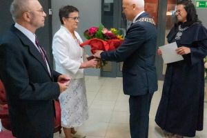 burmistrz wręcza bukiet kolorowych kwiatów jubilatce