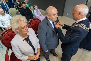 burmistrz przypina jubilatowi medal za długoletnie pożycie