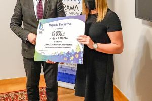 Główna nagroda w konkursie, burmistrz przekazuje bon za I miejsce