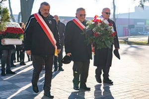trzyosobowa delegacja kombatantów przed tablicą Danuty Siedzikówny "Inki"